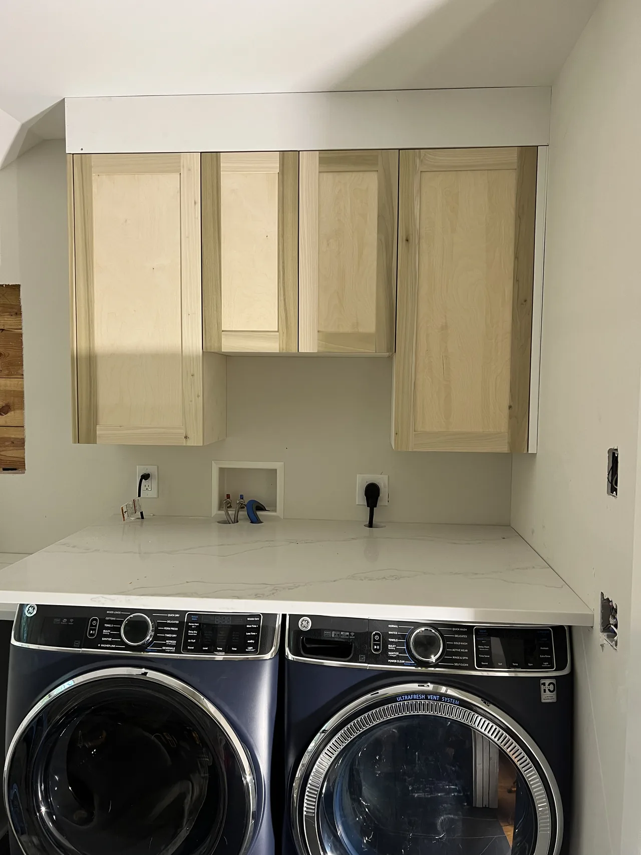 During installation: upper cabinets above laundry appliances