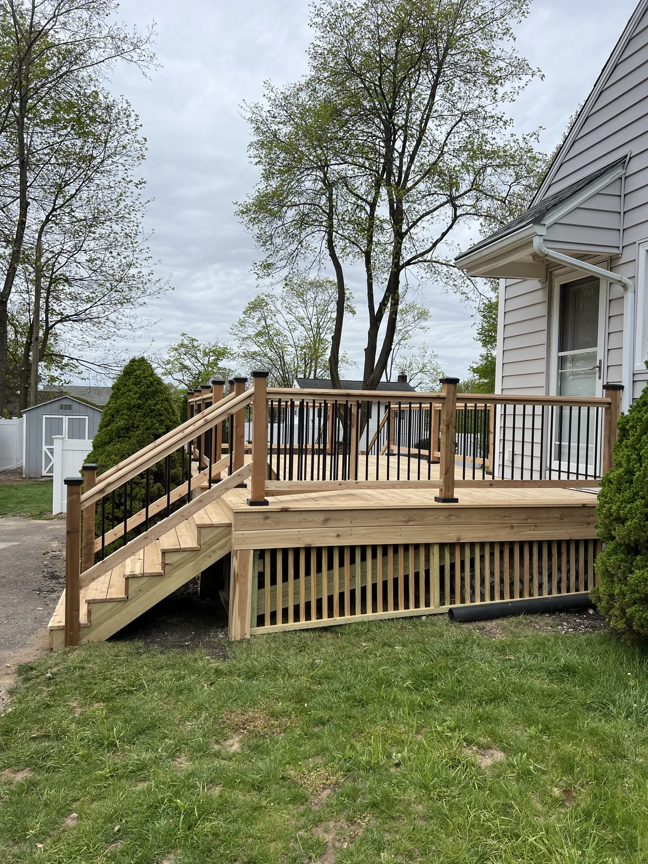 Wood deck after rebuilding, with stairs and black rail balusters